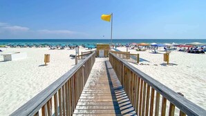 A wooden boardwalk leading to a beach with umbrellas and beachgoers. - Beach Baby 808/ Beachfront Beauty/ The Beach Club (Gulf Shores)