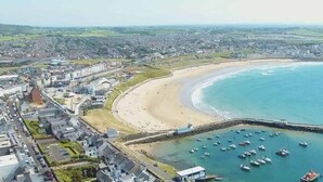 An aerial view of a coastal town with a beach, marina, and residential area. - Princess Green - Portrush by the Sea (Portrush)