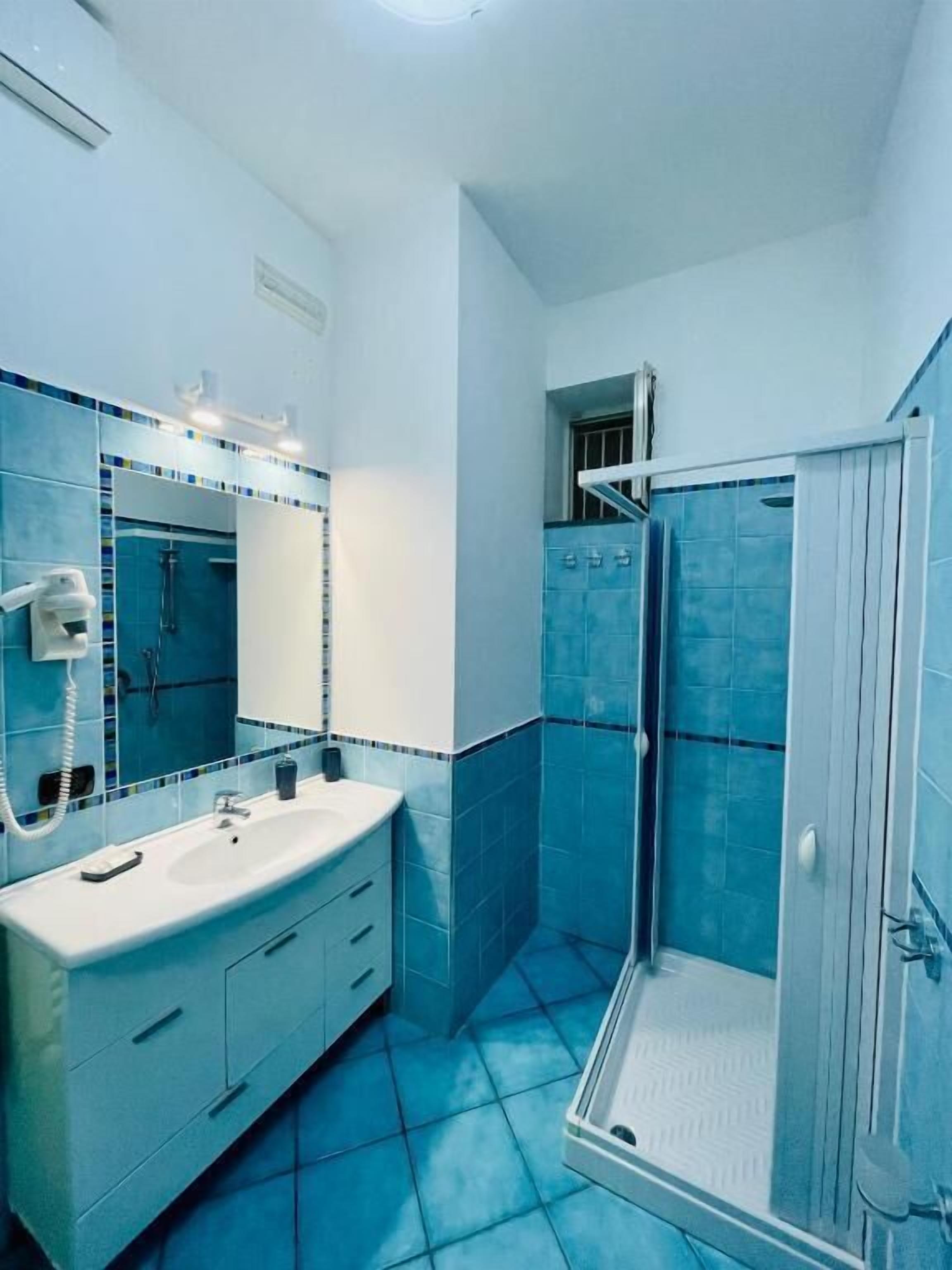 Ein Badezimmer mit Dusche, Waschbecken und Spiegel.