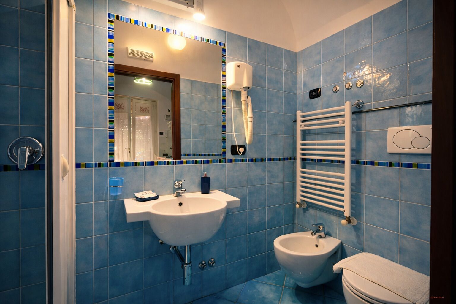 Un bagno con lavandino, bidet e porta asciugamani.