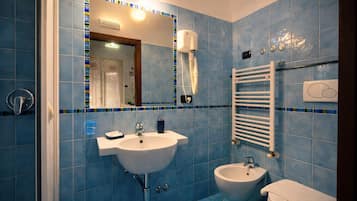 Un bagno con lavandino, bidet e porta asciugamani.