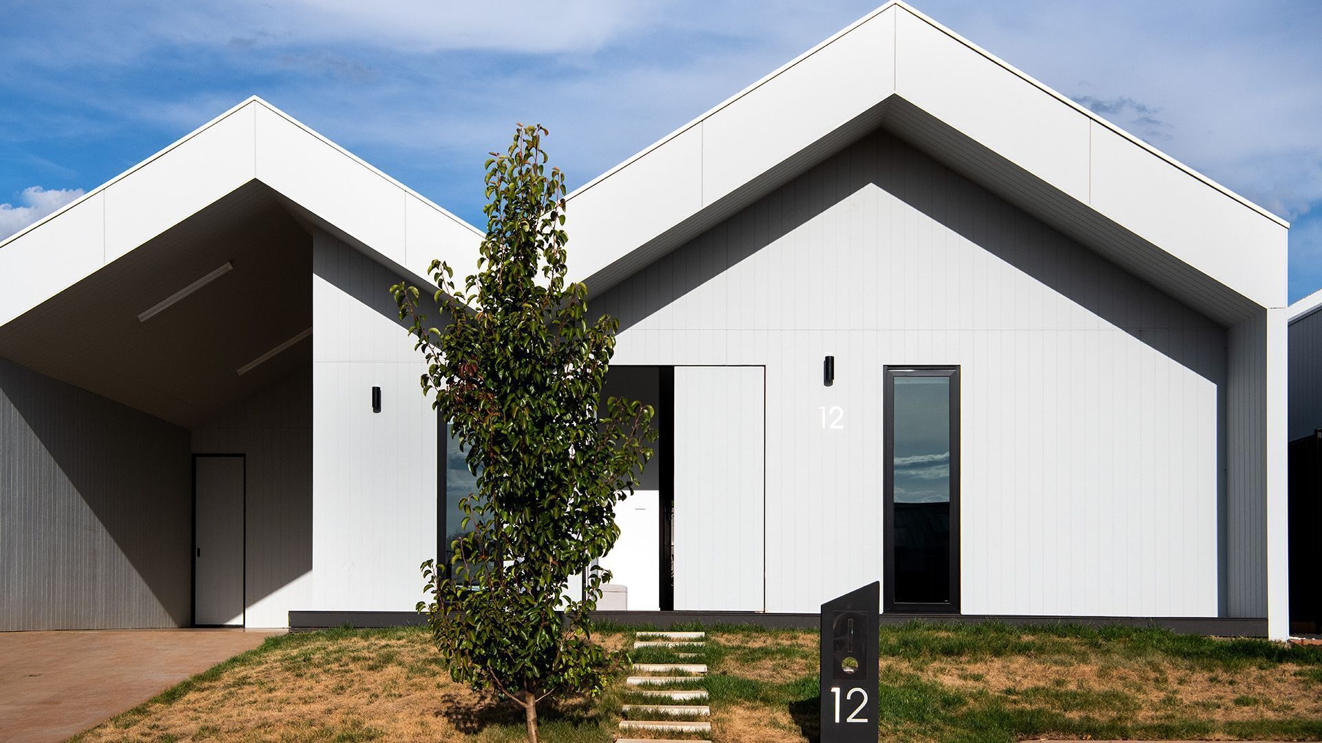 Ein modernes Gebäude mit Flachdach, großen Fenstern und minimalistischem Design.