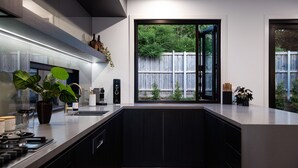 Eine moderne Küche mit großem Fenster, eingebauten Geräten und minimalistischem Design.