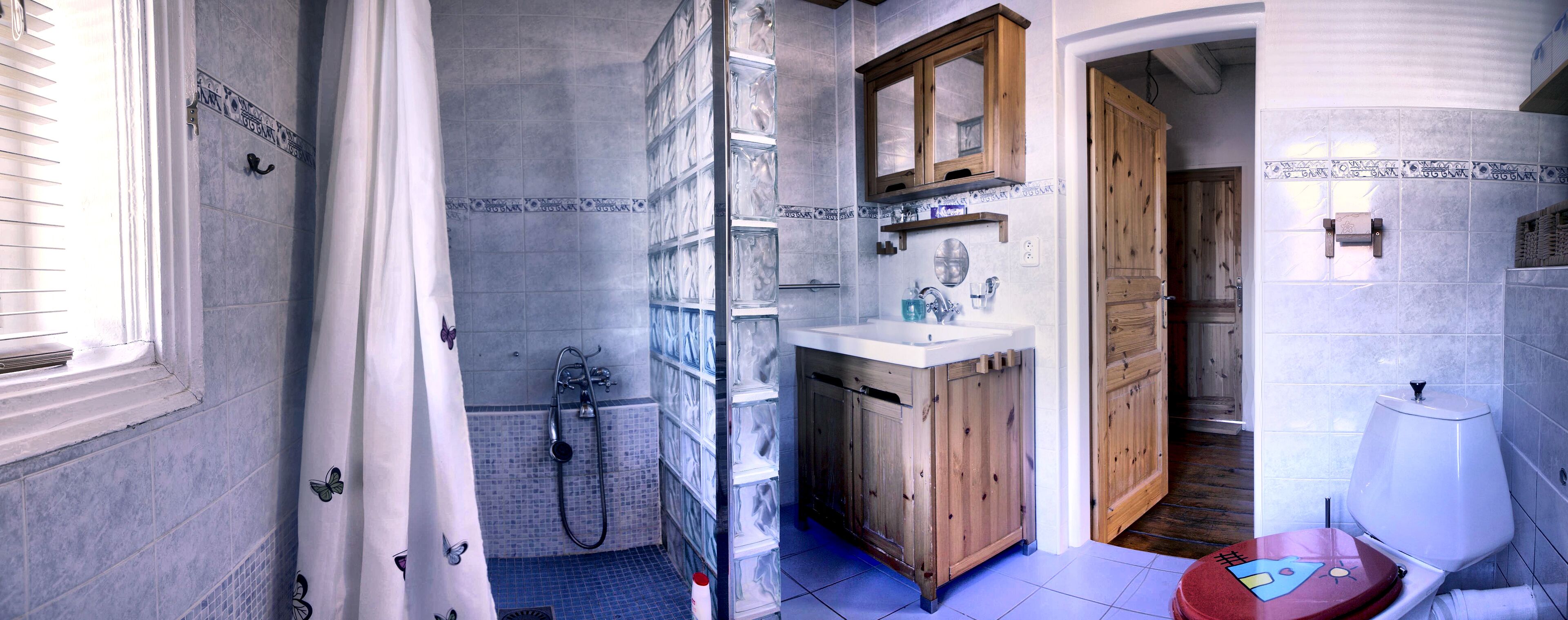 A bathroom with a shower, toilet, and sink.