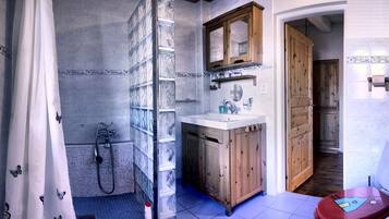 A bathroom with a shower, toilet, and sink.