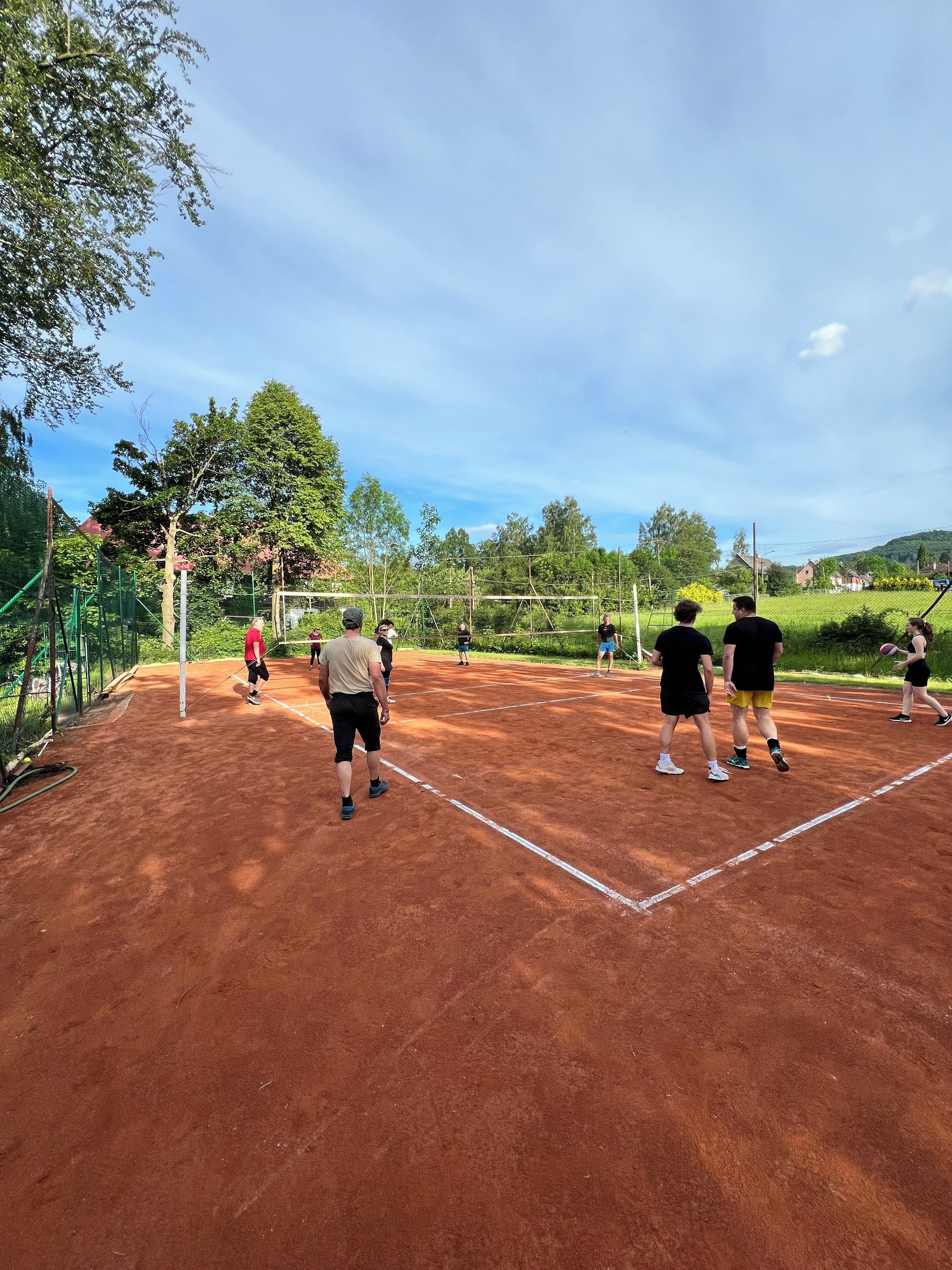 Una cancha de tenis con jugadores y una red.