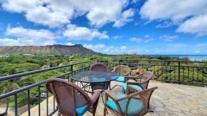 Relax on the balcony with a view of the lush landscape and distant mountain.