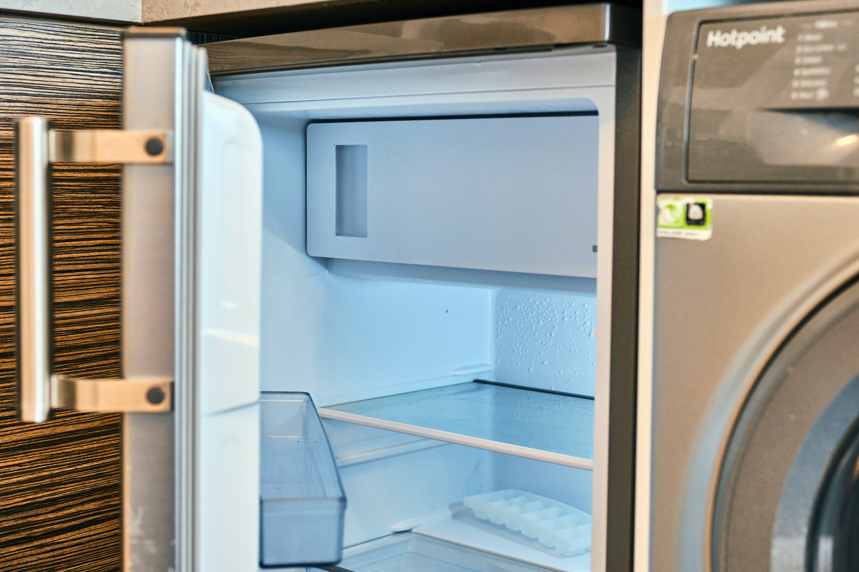 Un refrigerador abierto con un compartimento congelador y un microondas.