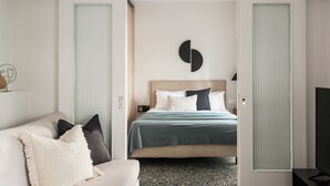 A modern hotel room with a bed, a sofa, and a TV. - Glorious 1BR Apartment in Athens (Athens)