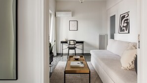 A modern living room with a sofa, a coffee table, a chair, and a desk. - Glorious 1BR Apartment in Athens (Athens)