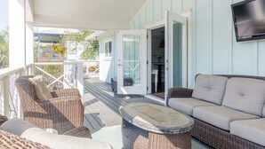 A covered outdoor seating area with wicker furniture and a glass door leading to a room. - Private Pool + STEPS to Beach! LSV/Golf Cart, Bikes, Pet Friendly! Coastal Charmer! (Santa Rosa Beach)