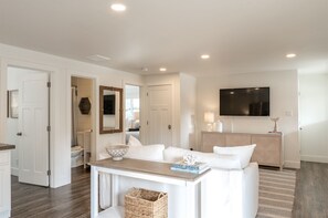 Relax in this stylish living space with a sofa, coffee table, and flat-screen TV.