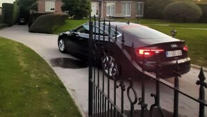 Une maison à deux étages avec une allée et une voiture garée.