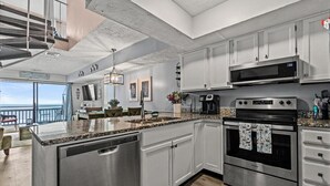 A modern kitchen with stainless steel appliances, white cabinetry, and a large island. - Condo w/ Private Balcony & Stunning Views | Family Friendly (Garden City Beach)