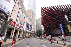 Una calle con edificios, un paso de peatones y una gran estructura roja.