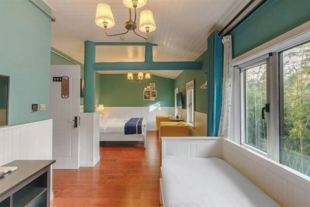 Une pièce avec un lit, un bureau, une fenêtre et une porte.