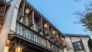 Ein traditionelles Gebäude mit Balkon, Holzgeländern und zahlreichen Fenstern.
