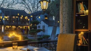 Ein gemütlicher Außenbereich mit Tisch, Stuhl und Bücherregal.
