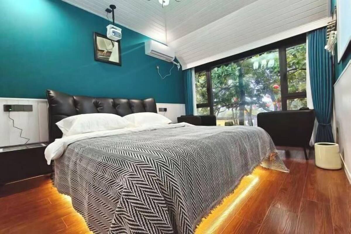 Une chambre à coucher avec un lit, une fenêtre donnant sur un beau paysage et un appareil de climatisation.