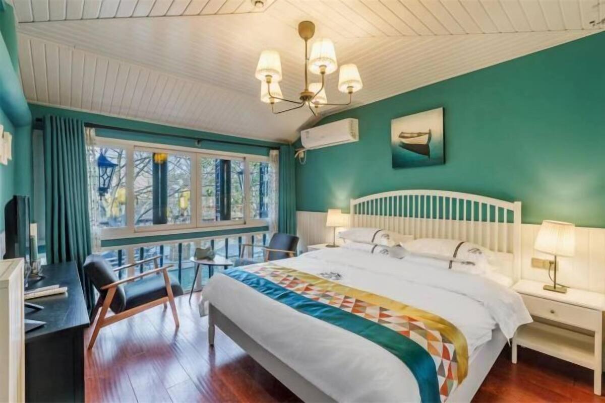 Une chambre à coucher avec un lit, des tables de chevet, un bureau et une chaise.