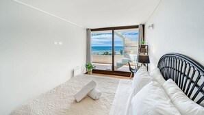 A bedroom with a bed, a view of the sea, a small balcony, and a window with curtains. - Miramar Deluxe con Vista al Mar (Concón)