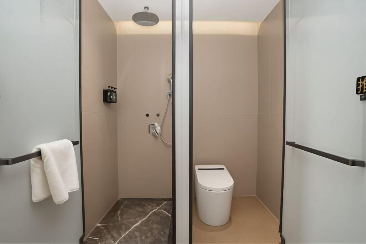 Ein modernes Badezimmer mit Glasdusche, Toilette und integriertem Waschtisch.