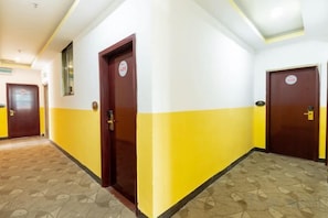 A hotel corridor with doors, patterned carpet, and a ceiling with recessed lighting. - Danzhou Hongyunting Hotel (Danzhou)