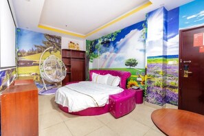 Een slaapkamer met een bed, een hangstoel, een garderobe en een deur.