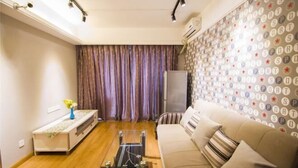 Ein Wohnzimmer mit einer Couch, einem Couchtisch, einem Fernseher und einer Wand mit Muster.