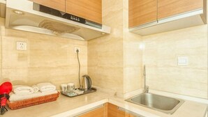 Eine moderne Küche mit Holzausbau, einem Edelstahl-Spülbecken und einem Wasserkocher auf der Arbeitsplatte.