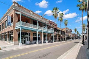A street view with a building featuring a balcony and a 'Coming Soon' sign.