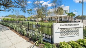 A sign for Fourth & Angel Dog Park with a paved walkway and a fence. - Casa Romeo | Gorgeous Ybor Apt, Steps to 7th Ave (Tampa)