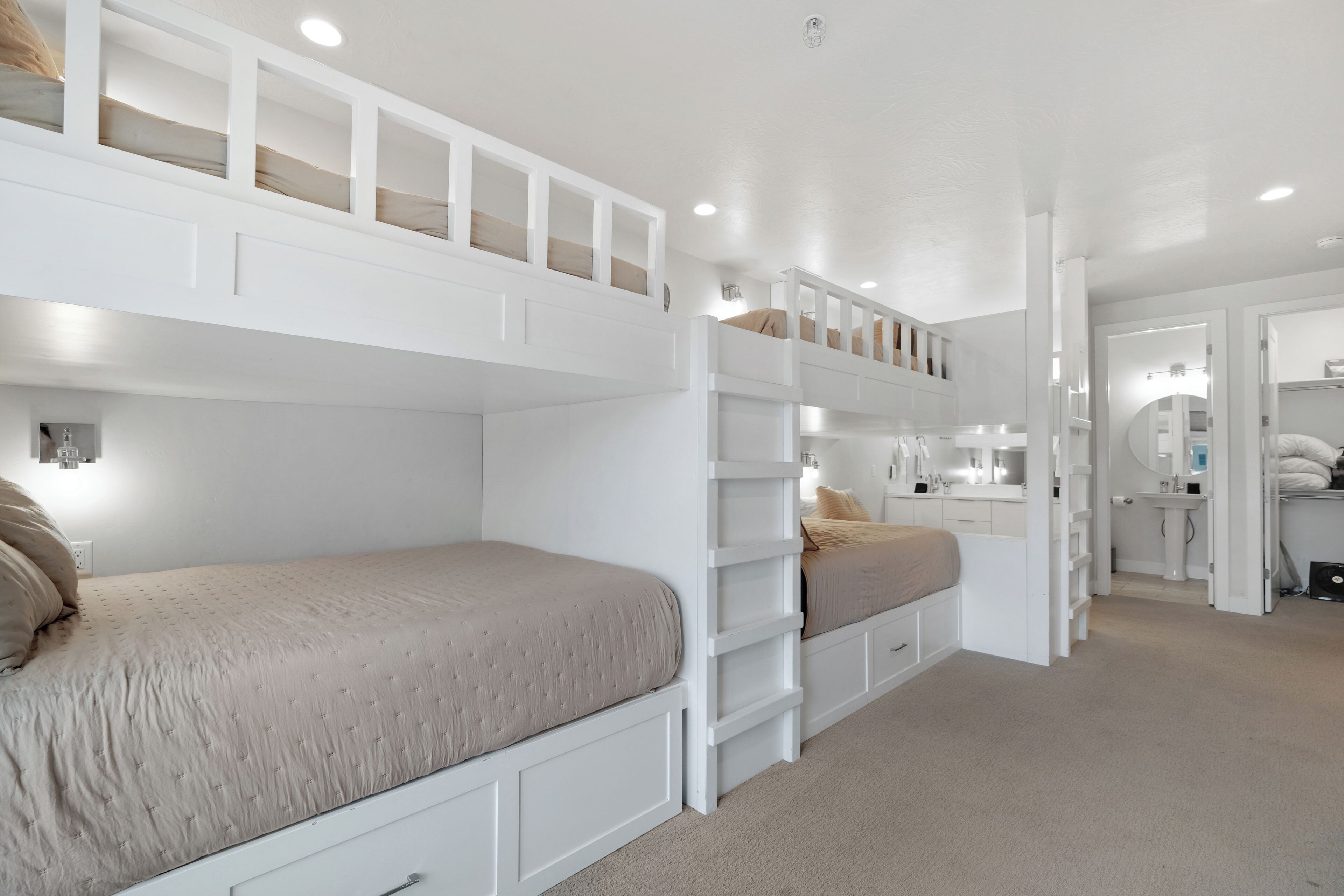 Un dormitorio con literas, un tocador con espejo y un vestidor.