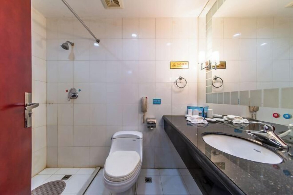 Une salle de bain moderne équipée de toilettes, d’une douche et d’un lavabo.