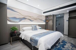 Une chambre d’hôtel moderne avec un grand lit, une table de chevet agrémentée d’une plante et une œuvre d’art accrochée au mur.