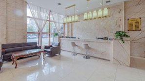 A modern lobby with a marble reception desk, bar stools, a sofa, and a large window with sheer curtains. - Dingyi Junyue Hotel (Changde)