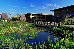 A hotel with a water feature, a bridge, and traditional-style buildings. - Chaohu Fragrant Hotspring Spa Resort (He County)