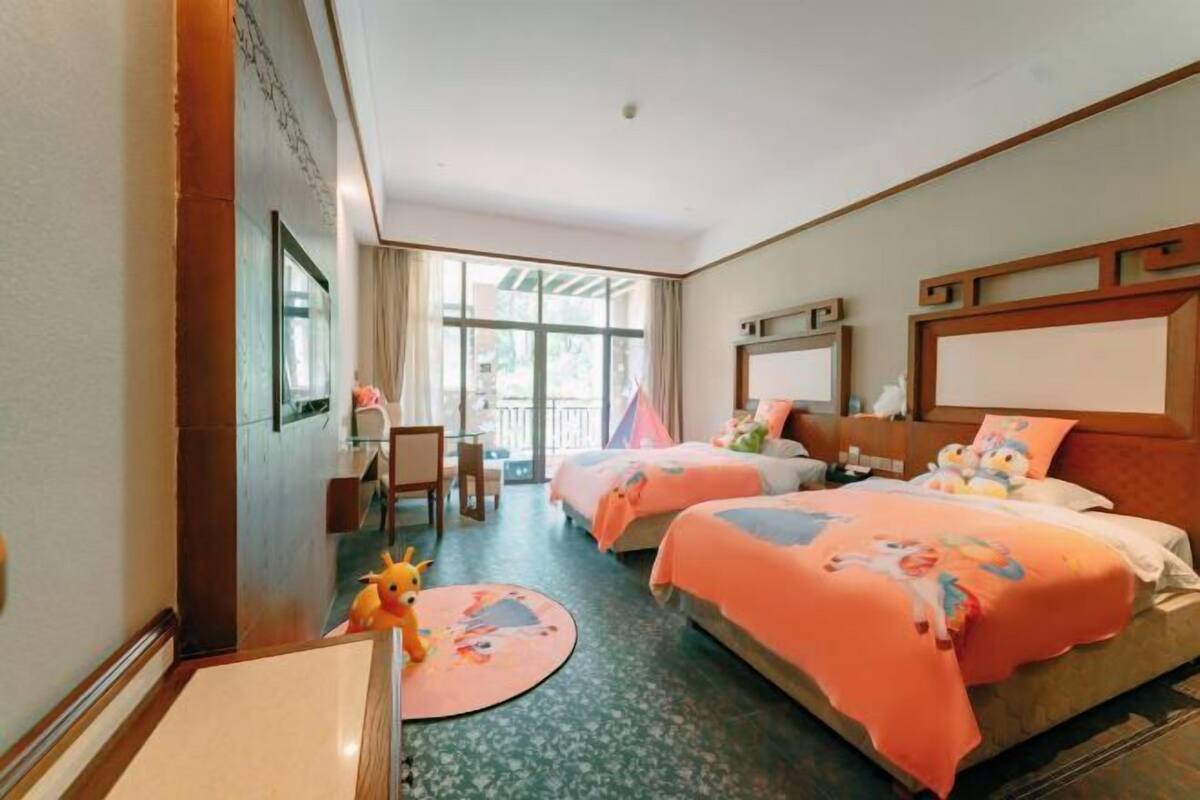 Ein Hotelzimmer mit zwei Betten, einem Schreibtisch und einem Stuhl.