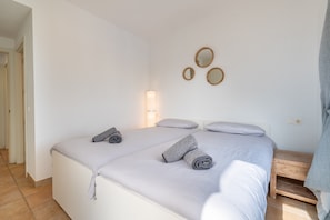 Une chambre à coucher comprenant un lit, une table de chevet, des miroirs fixés au mur et un luminaire.