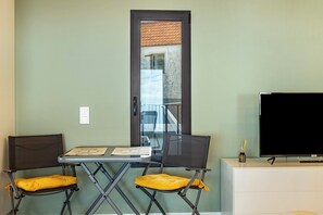 Una habitación con un escritorio, dos sillas, un televisor y una puerta.