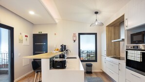 A modern kitchen with a built-in microwave, toaster, and sink. - Apartment 'Referta Apartamento T1' with Sea View, Private Terrace and Wi-Fi (Prazeres)