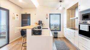 A modern kitchen with a central island, a microwave, and a sink. - Holiday Home 'Referta House' with Sea View, Private Garden and Wi-Fi (Prazeres)