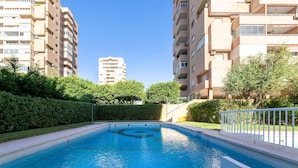 Una piscina rodeada de edificios de apartamentos, con un cielo despejado.