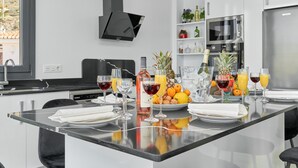 Een moderne keuken met een centraal eiland, een magnetron en een ingebouwde oven.