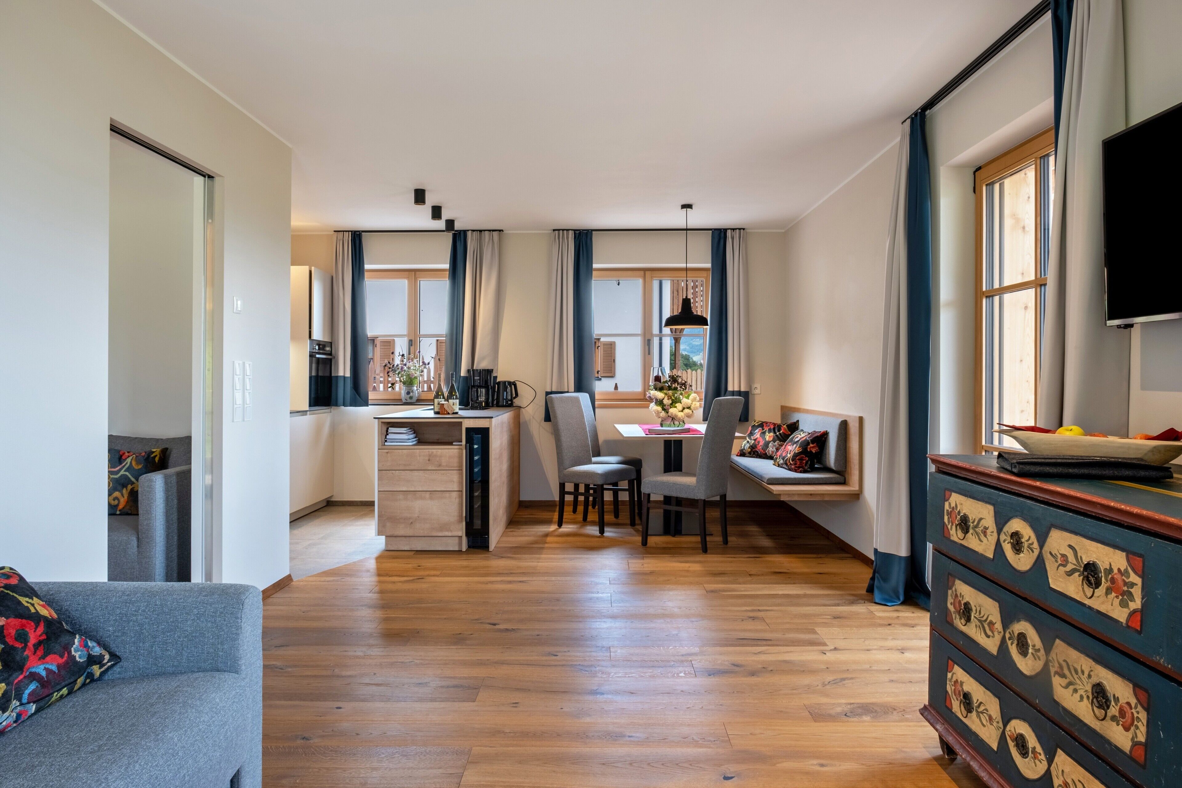 Un salon moderne avec un canapé, un coin repas et une cuisine en arrière-plan.