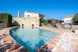 A swimming pool with stone walls and a clear blue water feature.