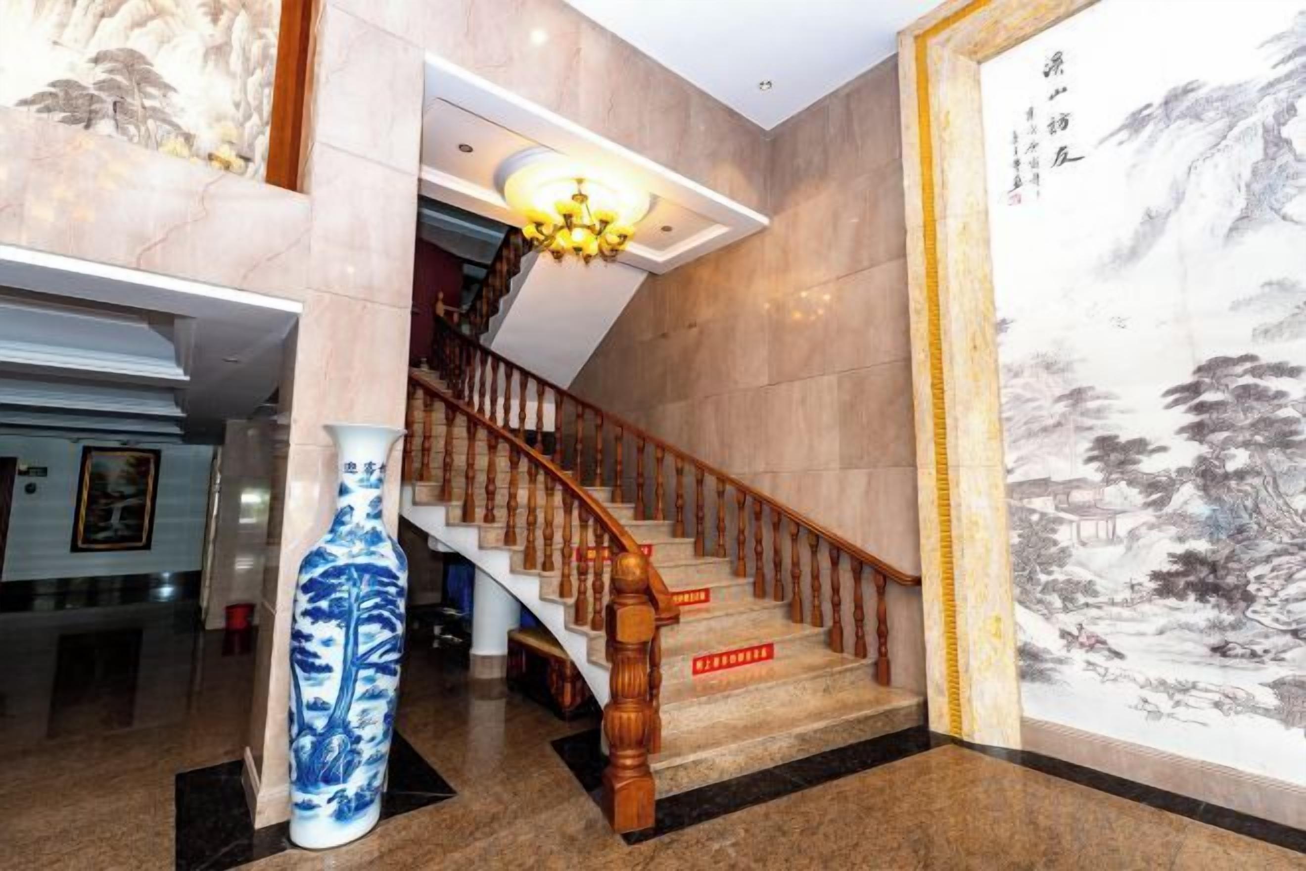 Eine Treppe mit hölzernem Geländer, einer Vase und einem großen Gemälde an der Wand.