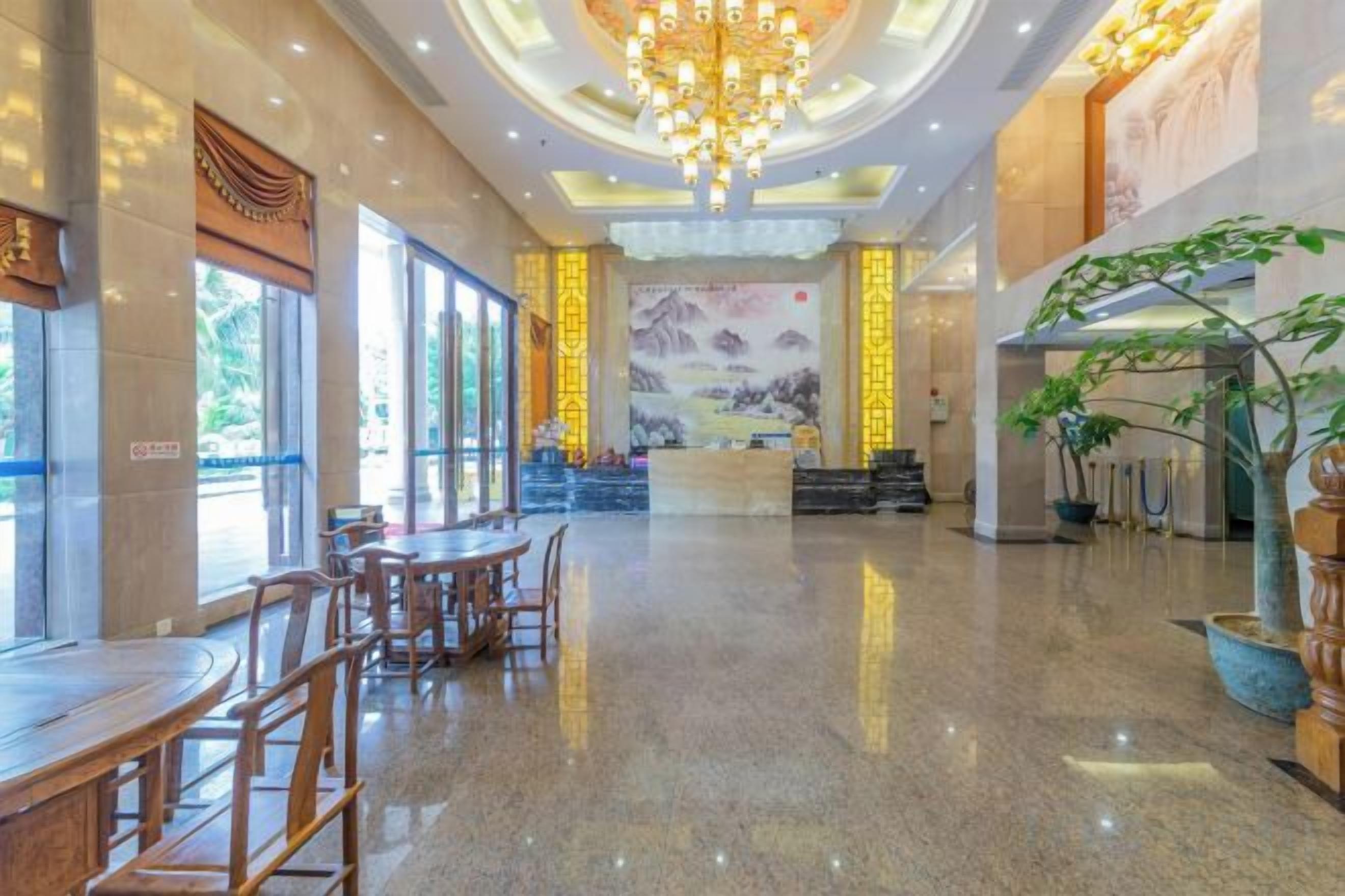 A spacious lobby with a reception desk, seating area, and a chandelier.