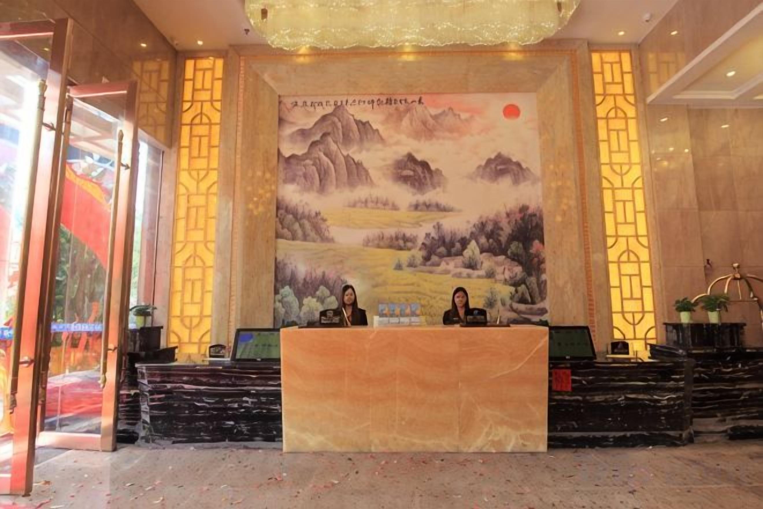 A reception area with a large mural, a reception desk, and a staircase leading to an upper level.