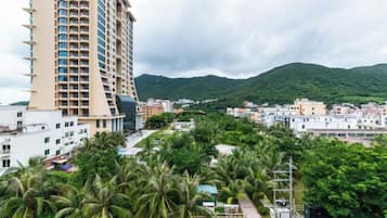 A high-rise building with multiple floors, surrounded by greenery and other buildings.
